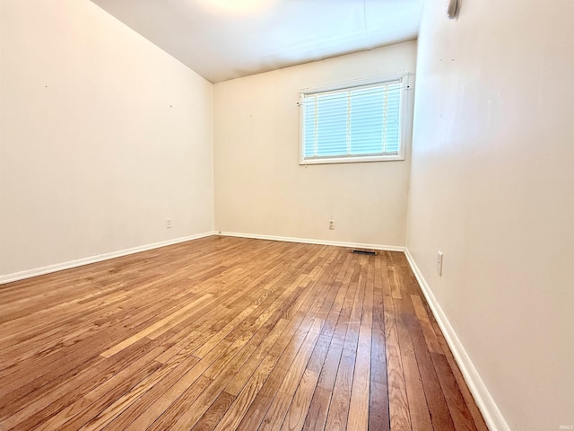 unfurnished room featuring baseboards and hardwood / wood-style floors