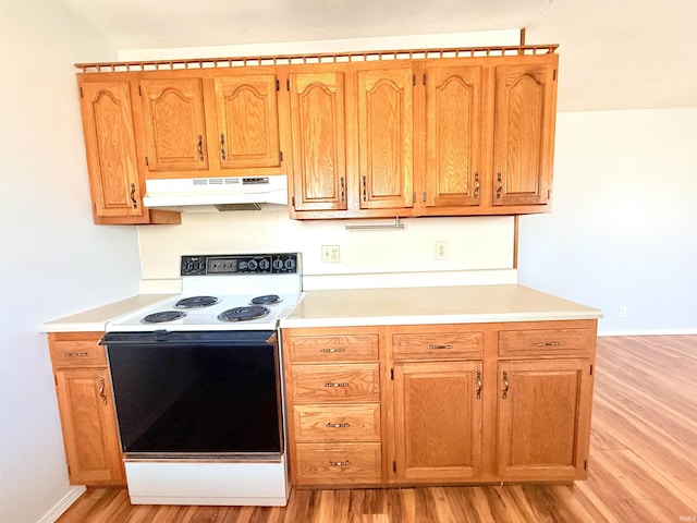 kitchen featuring baseboards, light wood-style flooring, electric range oven, light countertops, and under cabinet range hood