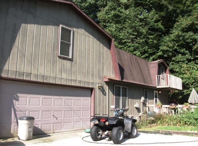 view of front of home with a gambrel roof, driveway, and an attached garage