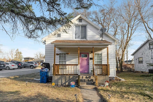 shotgun-style home with a porch and a front lawn