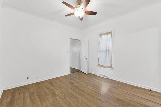 unfurnished room with wood finished floors, baseboards, visible vents, ceiling fan, and ornamental molding