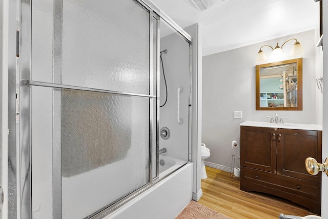 full bath featuring visible vents, toilet, wood finished floors, enclosed tub / shower combo, and vanity