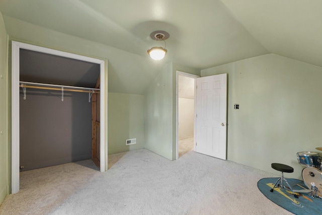 unfurnished bedroom with vaulted ceiling, visible vents, a closet, and carpet floors