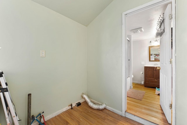 laundry area with visible vents, a sink, baseboards, and wood finished floors