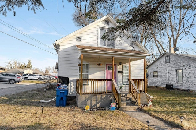 view of front of property featuring a porch, central AC unit, and a front yard