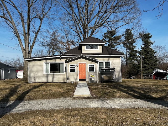 view of front of property featuring metal roof and a front lawn