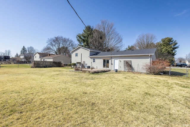 rear view of house with a patio, a lawn, and fence