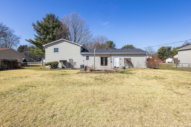 rear view of house with a yard and fence