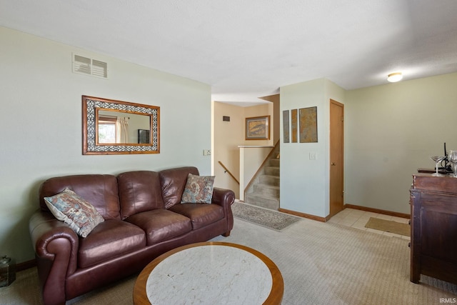 living room featuring stairs, light colored carpet, visible vents, and baseboards