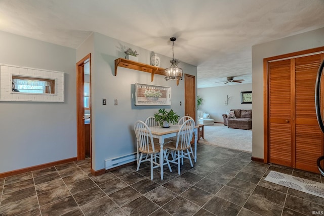 dining room featuring baseboard heating, an inviting chandelier, and baseboards