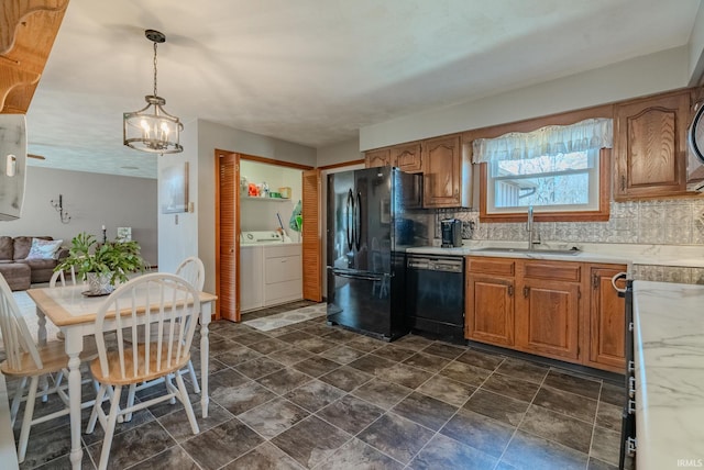 kitchen with tasteful backsplash, washer and clothes dryer, light countertops, black appliances, and a sink