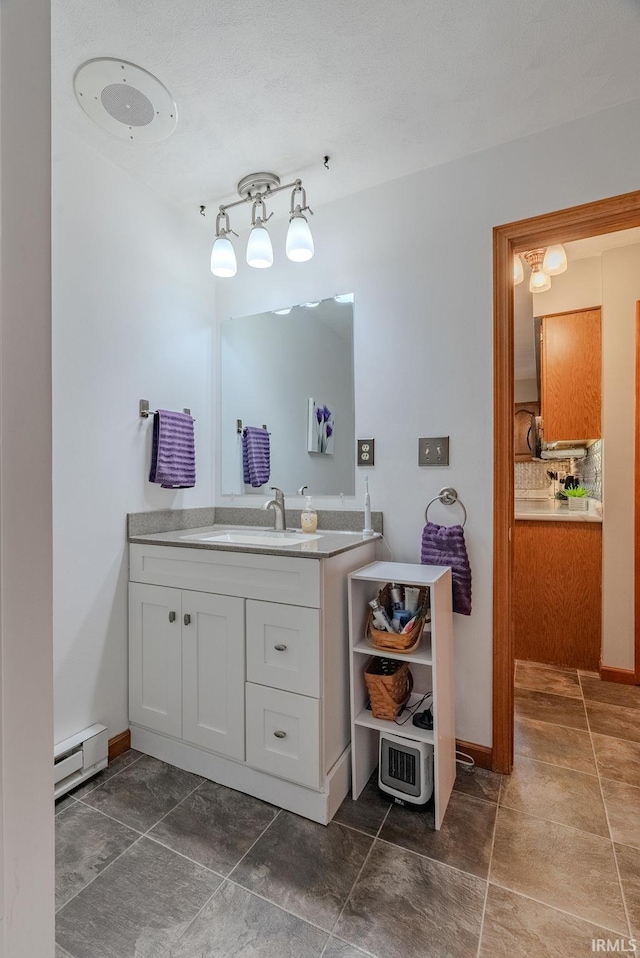 bathroom featuring vanity, baseboards, and baseboard heating