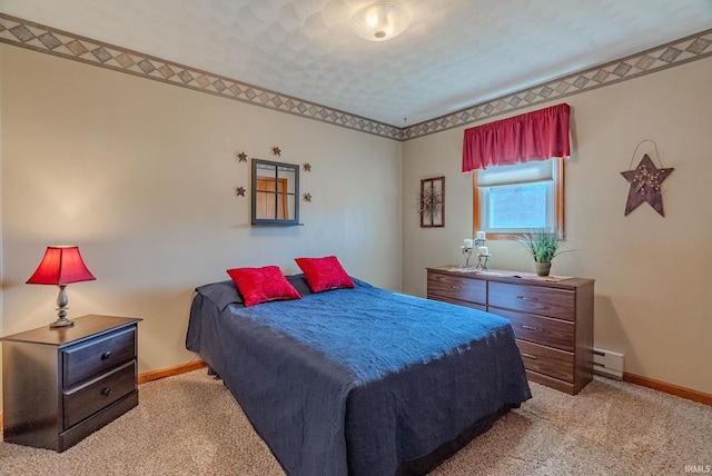 carpeted bedroom featuring a baseboard heating unit and baseboards