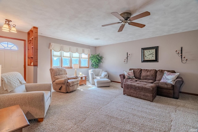 carpeted living room with ceiling fan, a textured ceiling, and baseboards