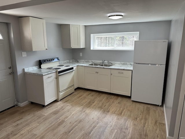 kitchen featuring light wood-style flooring, white appliances, white cabinetry, and a sink