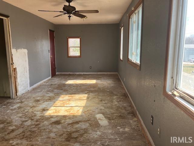 unfurnished room with baseboards and ceiling fan