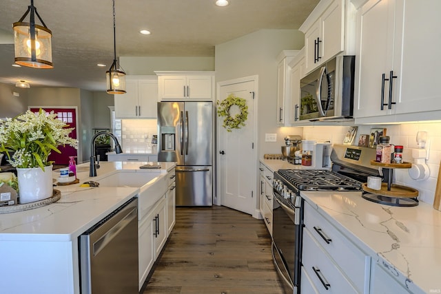 kitchen featuring a sink, tasteful backsplash, dark wood-style floors, white cabinetry, and appliances with stainless steel finishes