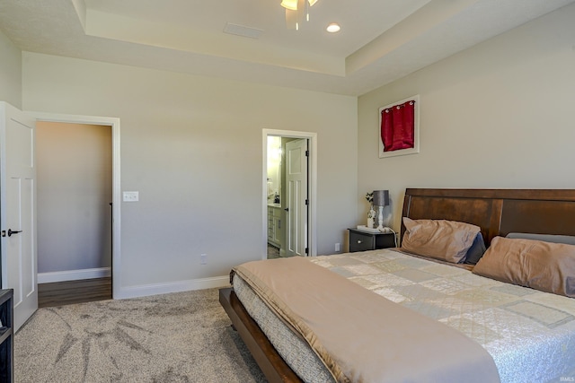 bedroom with connected bathroom, baseboards, a tray ceiling, carpet flooring, and recessed lighting