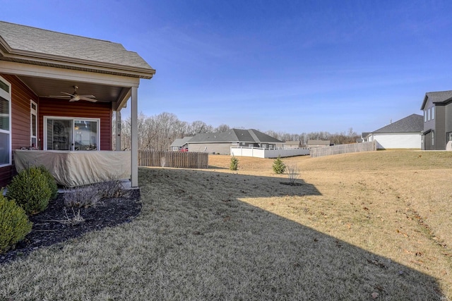 view of yard with ceiling fan and fence