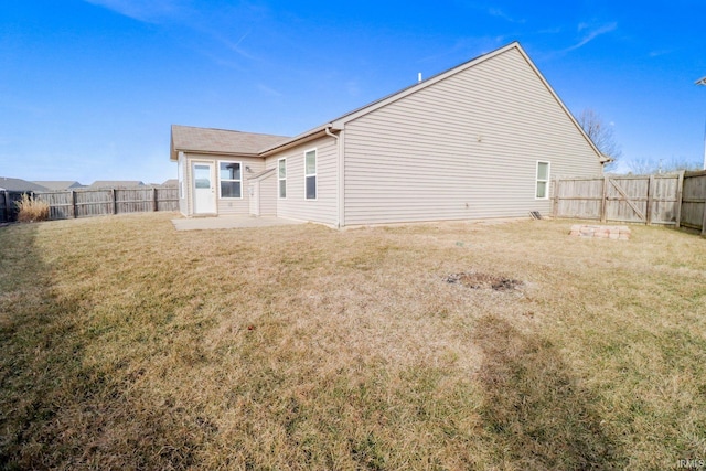 back of house featuring a patio area, a lawn, and a fenced backyard