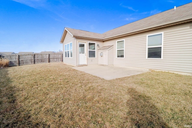 back of property with a yard, a patio area, and fence