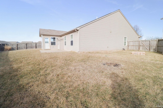 back of property with a patio area, a lawn, and a fenced backyard