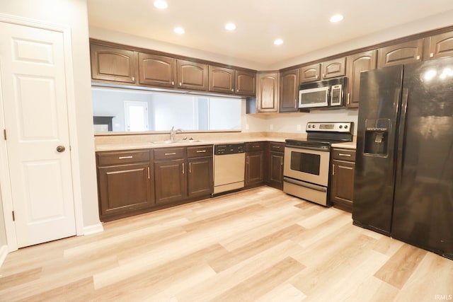 kitchen with light countertops, dishwashing machine, stainless steel electric range, black refrigerator with ice dispenser, and a sink