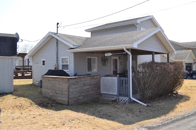 back of house with roof with shingles and covered porch