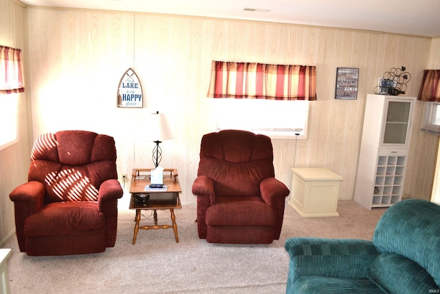 carpeted living area featuring visible vents and wood walls