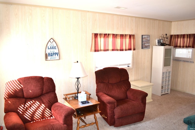 sitting room featuring carpet flooring and wood walls