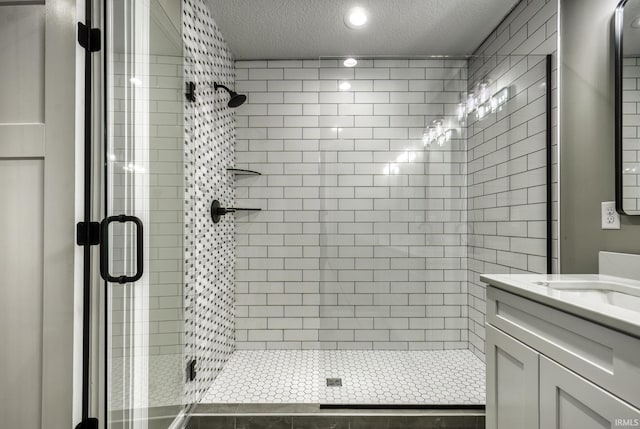 full bathroom with recessed lighting, vanity, a shower stall, and a textured ceiling