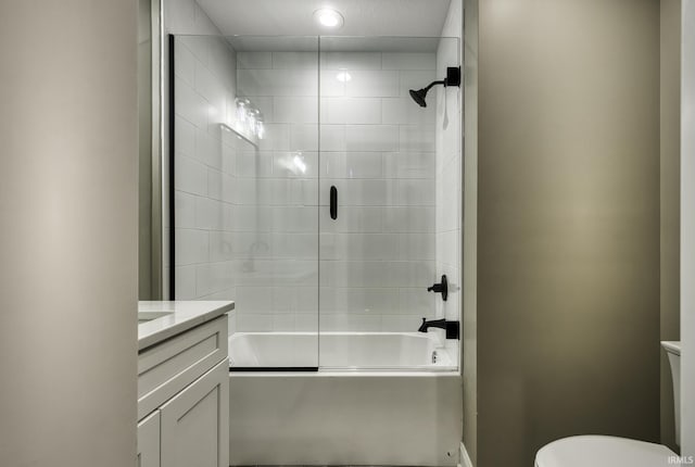 full bath with vanity, toilet, and bath / shower combo with glass door