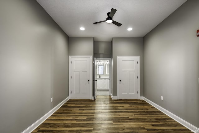 unfurnished bedroom with dark wood finished floors, recessed lighting, baseboards, and ensuite bathroom