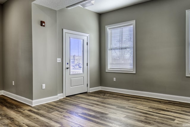 foyer entrance with baseboards and wood finished floors