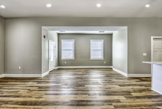 empty room featuring recessed lighting, dark wood-style floors, and baseboards