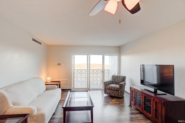 living area featuring ceiling fan, visible vents, and dark wood finished floors