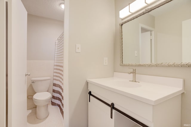 bathroom with vanity, tile patterned flooring, a textured ceiling, tile walls, and toilet