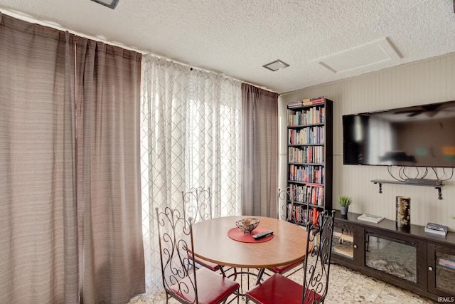 dining room featuring a textured ceiling and attic access