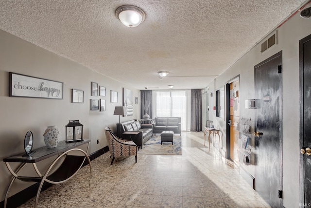 interior space featuring visible vents, a textured ceiling, and baseboards