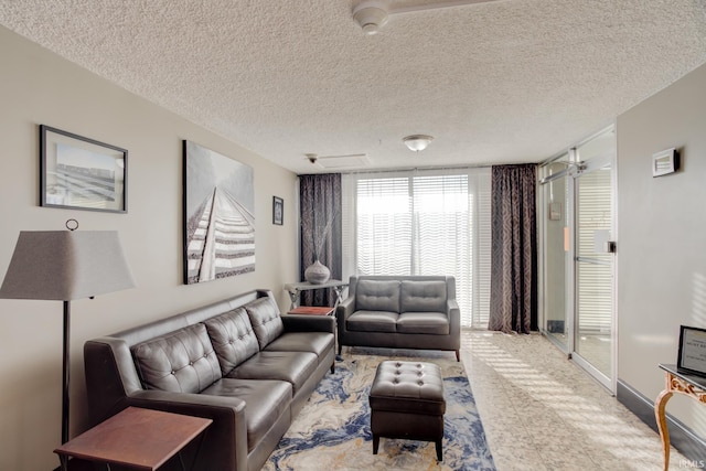 living area with baseboards and a textured ceiling