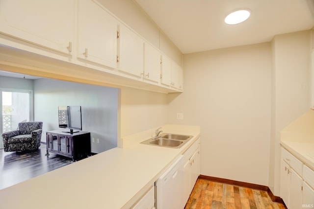 kitchen with light wood-style flooring, a sink, white cabinetry, light countertops, and dishwasher