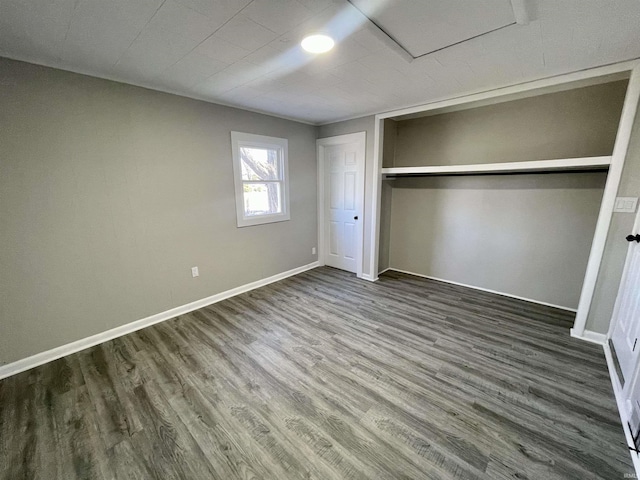 unfurnished bedroom featuring a closet, baseboards, and wood finished floors