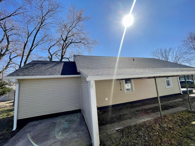 view of property exterior with a shingled roof