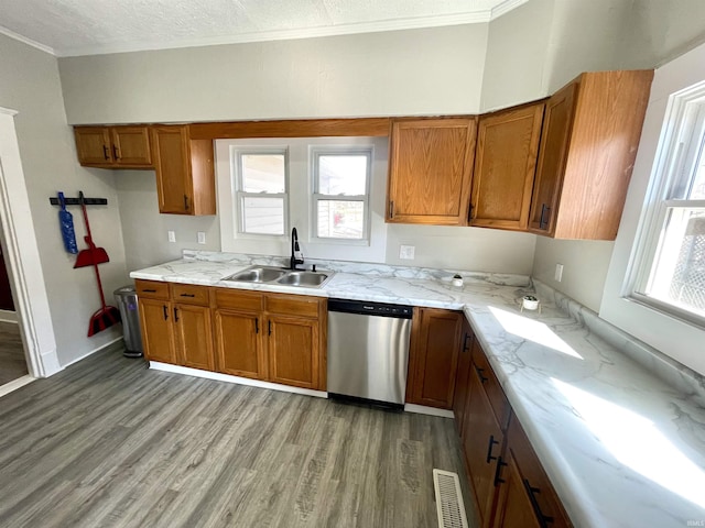 kitchen featuring brown cabinetry, visible vents, dishwasher, and a sink