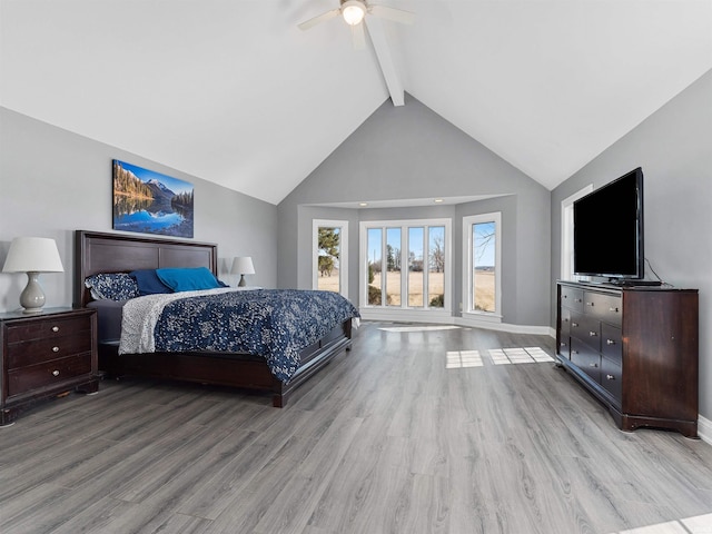 bedroom featuring baseboards, beam ceiling, wood finished floors, high vaulted ceiling, and a ceiling fan