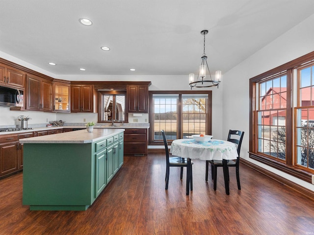 kitchen with dark wood-style floors, recessed lighting, stainless steel appliances, light countertops, and a chandelier