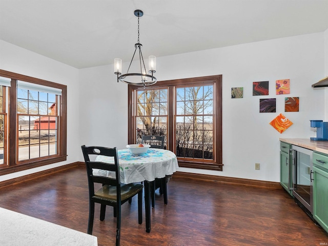 dining room with beverage cooler, an inviting chandelier, dark wood-type flooring, and baseboards