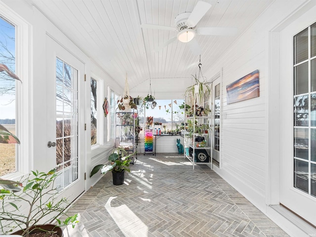 unfurnished sunroom featuring a healthy amount of sunlight, wooden ceiling, and vaulted ceiling