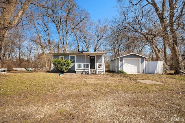 single story home with a front lawn, fence, covered porch, an outdoor structure, and a garage