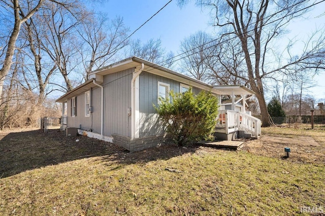 view of property exterior featuring a lawn and fence